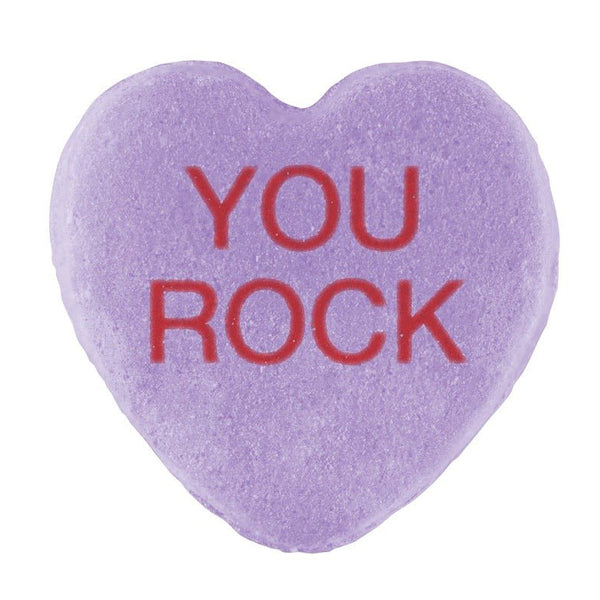 A purple heart-shaped Candy Hearts with "you rock" stamped in red text, isolated on a white background for Valentine's Day.