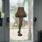 View from a window featuring a Cover-Alls Leg Lamp decal with a fringed shade, set between two black wall lamps, overlooking a street with colorful houses.