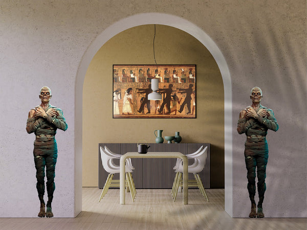 Two Egyptian Guard Mummy Zombie statues standing beside a dining table under an arched wall with an ancient Egyptian mural hanging above, transformed into Halloween decor by Cover-Alls.