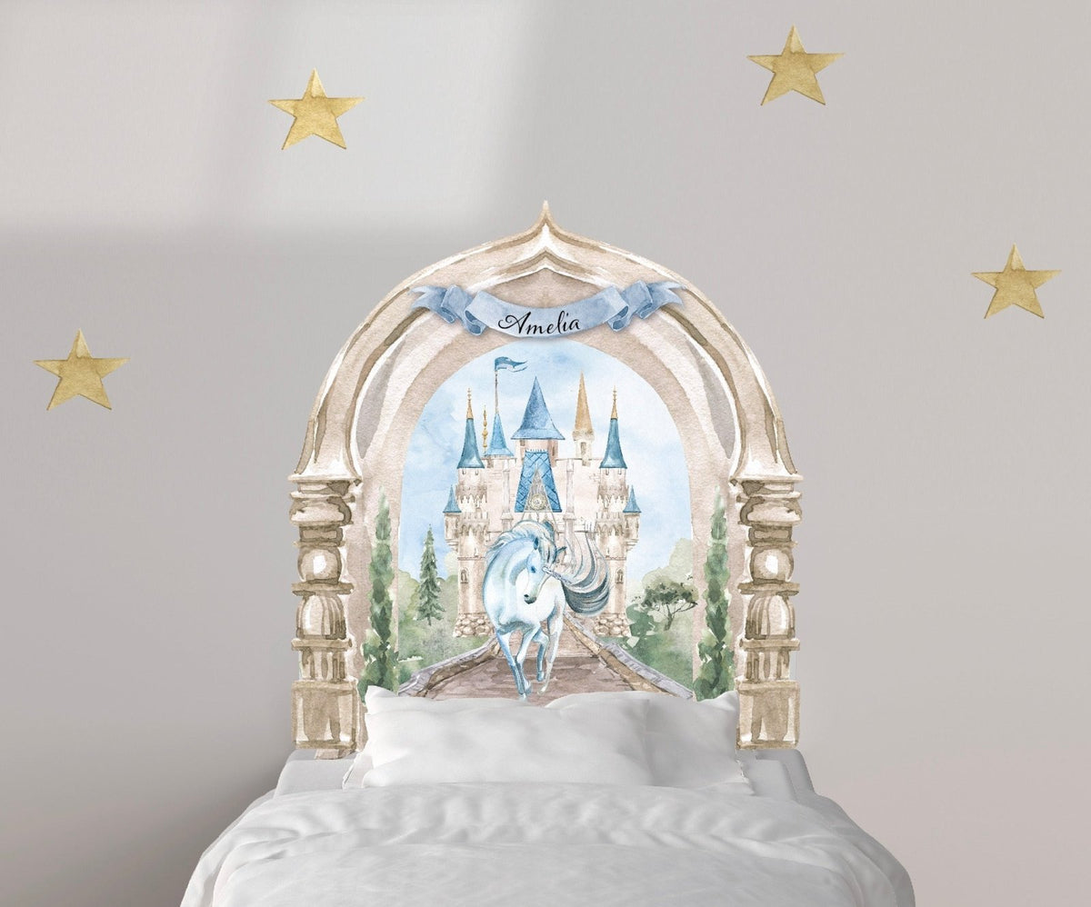 A child's bed with a custom Enchanted Castle with Unicorn Decal headboard by Cover-Alls, surrounded by decorative gold stars on the wall.