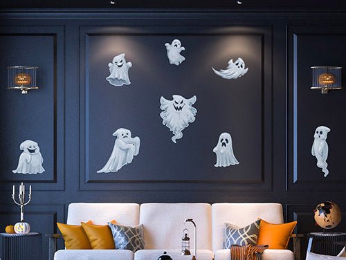 A stylish living room decorated for Halloween with a Cover-Alls Ghost Decal set on a dark wall, an orange and black themed sofa, and chic lighting.