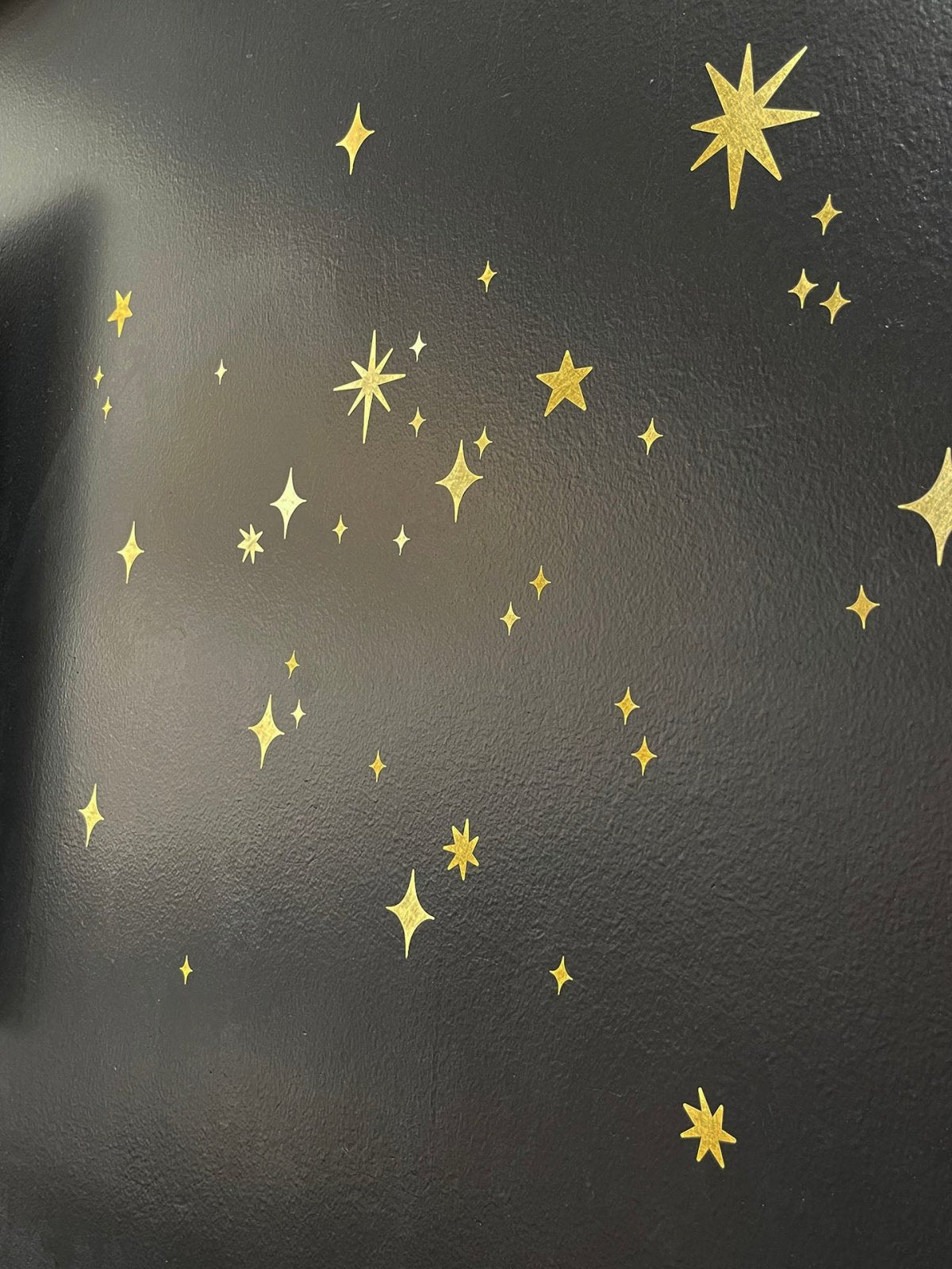 Gold Twinkly Stars stickers of various sizes and designs scattered on a dark textured surface, perfect for creating a magical scene decor. Brand Name: Cover-Alls