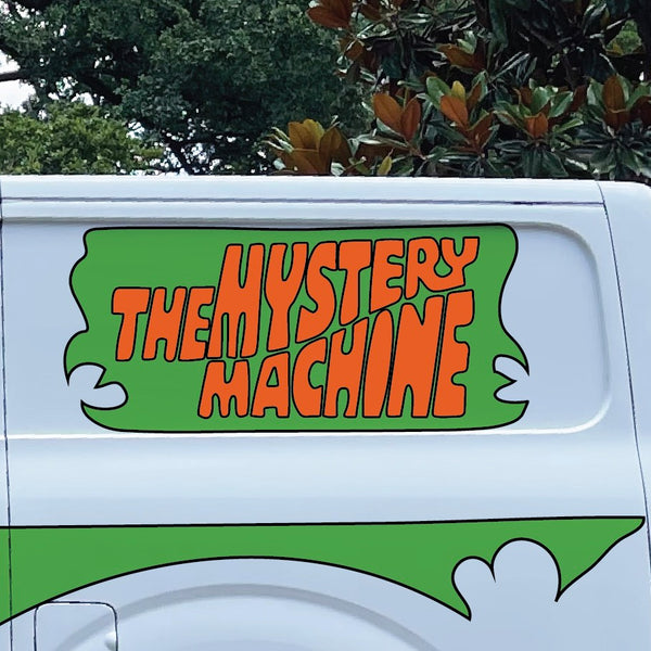 Side view of a white van with "Mystery Machine Kit" by Cover-Alls written in orange and green on the side, complete with custom decals reminiscent of Scooby Doo's iconic ride.