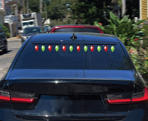 The rear window of a black car is adorned with green and red decorative lights, enhanced by Cover-Alls' Christmas Lights Decals, spreading holiday cheer wherever it goes.