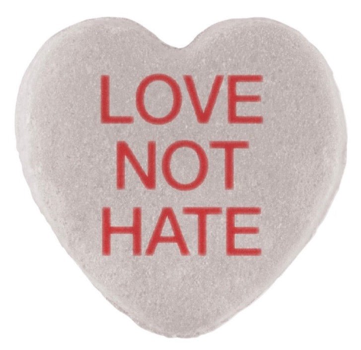 Heart-shaped Candy Hearts with the phrase "love not hate" printed in red text, perfect for Valentine's Day, by Cover-Alls.