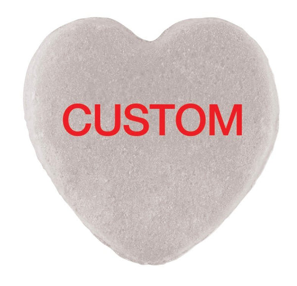 A heart-shaped object with a textured surface, featuring the word "CUSTOM" in red letters centered on it, perfect for Valentine's Day. - Candy Hearts by Cover-Alls.