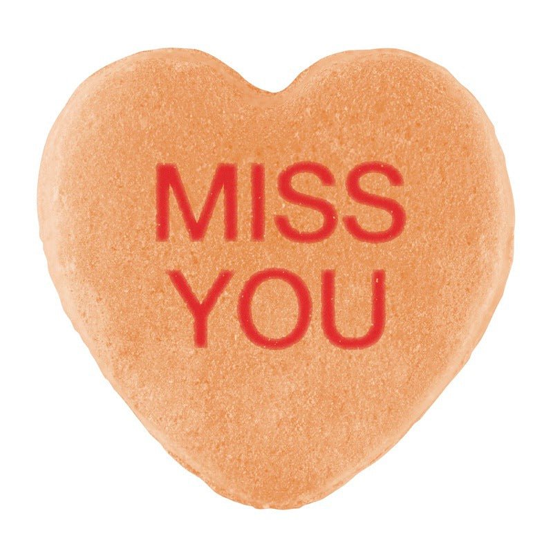 Heart-shaped cookie with a Candy Hearts design and the words "miss you" stamped in red on its surface from Cover-Alls.