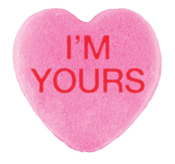 A pink heart-shaped candy with the phrase "i'm yours" embossed in red letters, perfect for Valentine's Day. Candy Hearts by Cover-Alls.