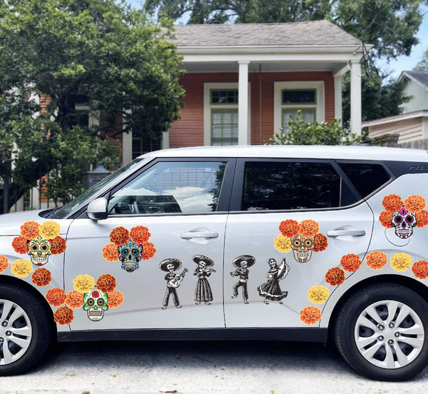 White SUV decorated with colorful Day of the Dead Mariachi Band-themed decals, including sugar skulls, parked in front of a house.