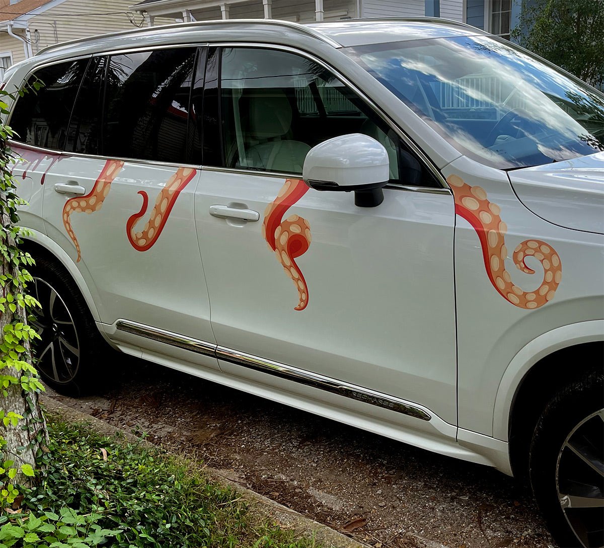 A white SUV parked by a house with Cover-Alls Eight Terrifying Tentacle Decals on the side panel.