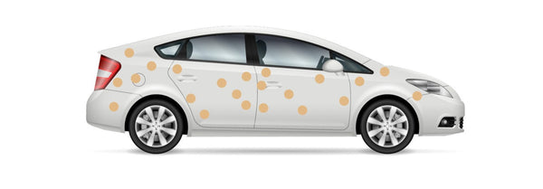 White sedan car with vibrant orange Cover-Alls Dot Decals, profile view, isolated on a white background.