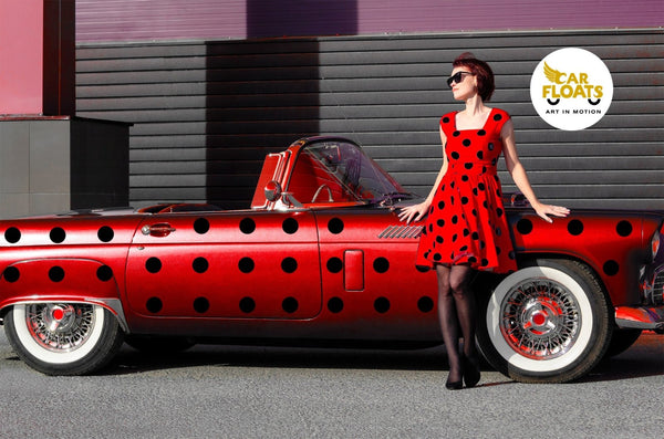 Woman in polka dot dress leaning on a vintage car decorated with CoverAlls Dot Decals.