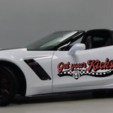 White Chevrolet Corvette with black and red trim, featuring Cover-Alls Route 66 decals, parked in a showroom.